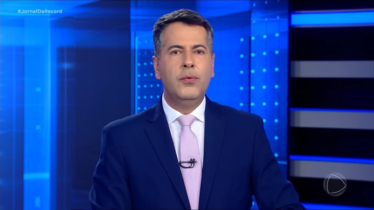 Foto do apresentador Clébio Cavagnolle na bancada do Jornal da Record