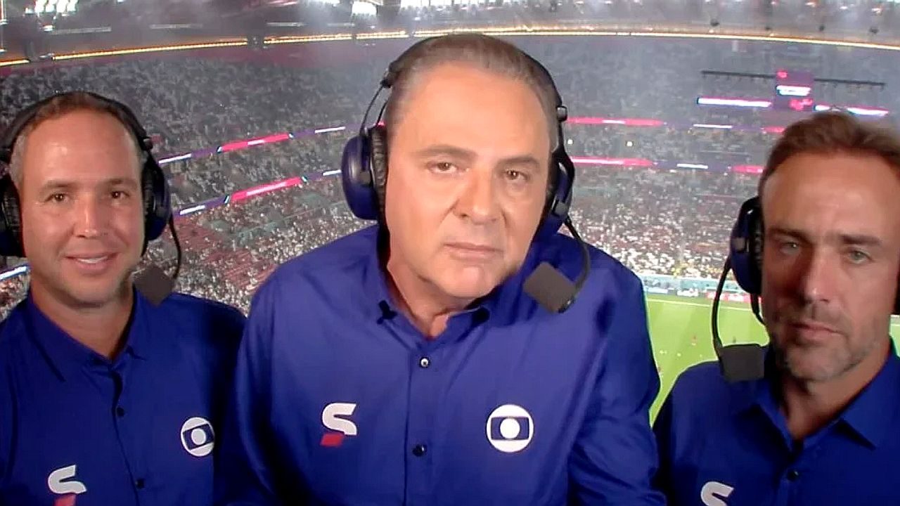 Trio de narradores e comentaristas da Globo usa headsets durante transmissão de jogo em estádio lotado