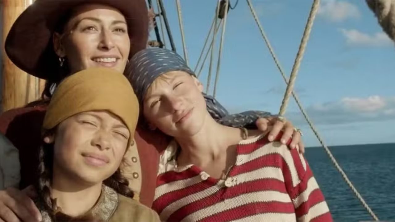 Mãe e duas crianças observam o horizonte em navio pirata em cena do filme exibido no Corujão