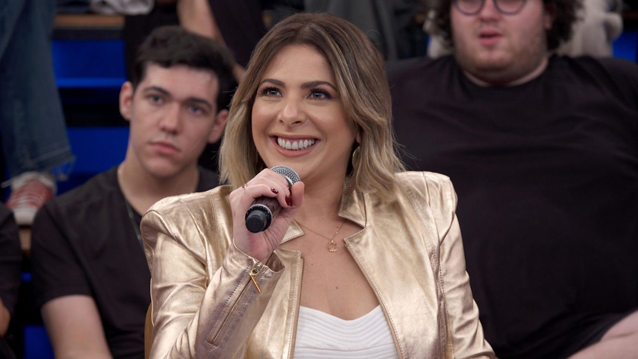 Daniela Lima sorrindo e segurando microfone durante participação no programa Altas Horas