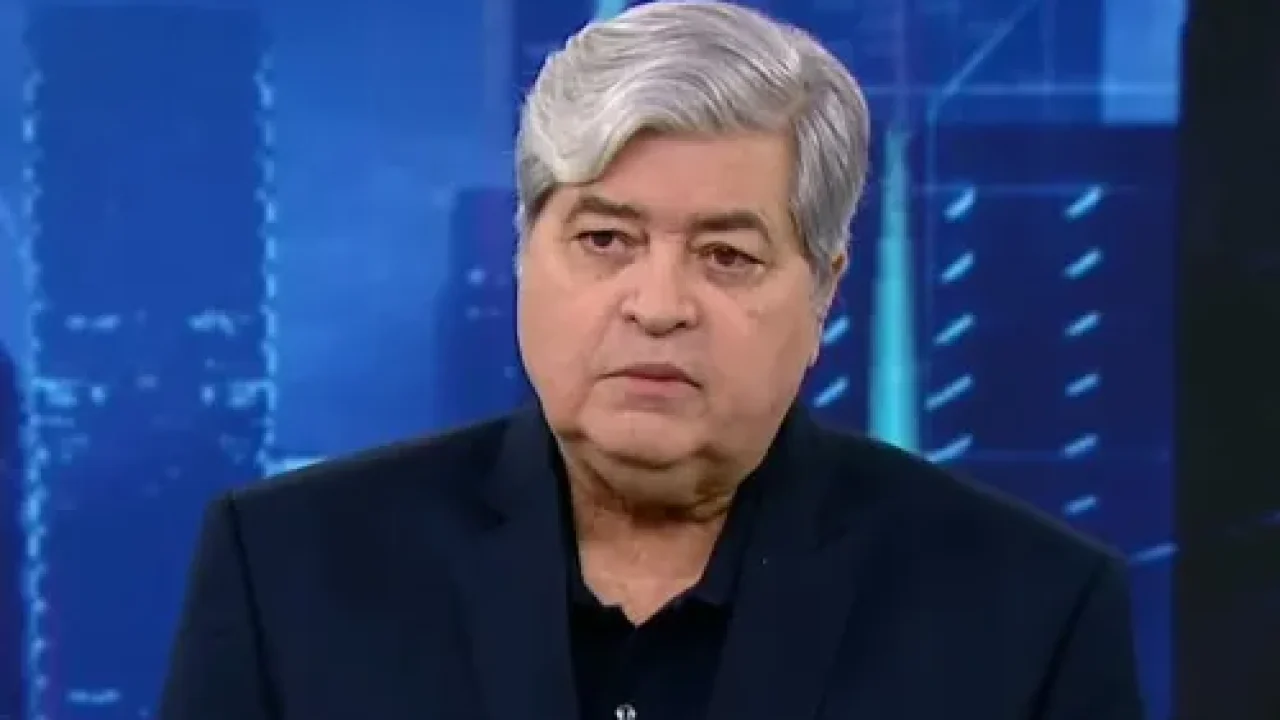 José Luiz Datena em um fundo azul no estúdio do SBT