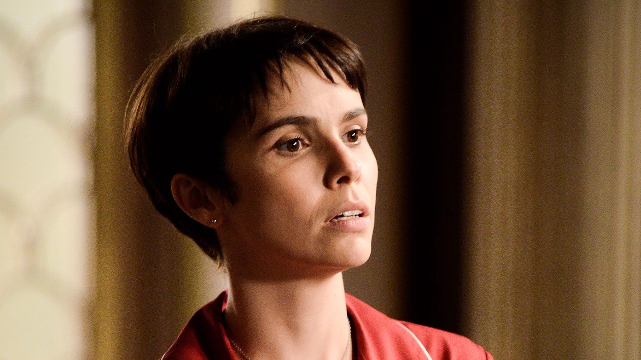 Débora Falabella como Nina com cabelo curto escuro e franja usando pijama vermelho em cena da novela Avenida Brasil