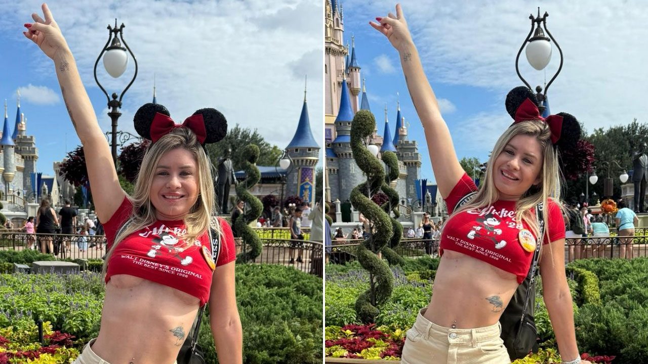 Débora Peixoto com tiara do Mickey posa sorridente em frente ao Castelo da Cinderela no Magic Kingdom da Disney