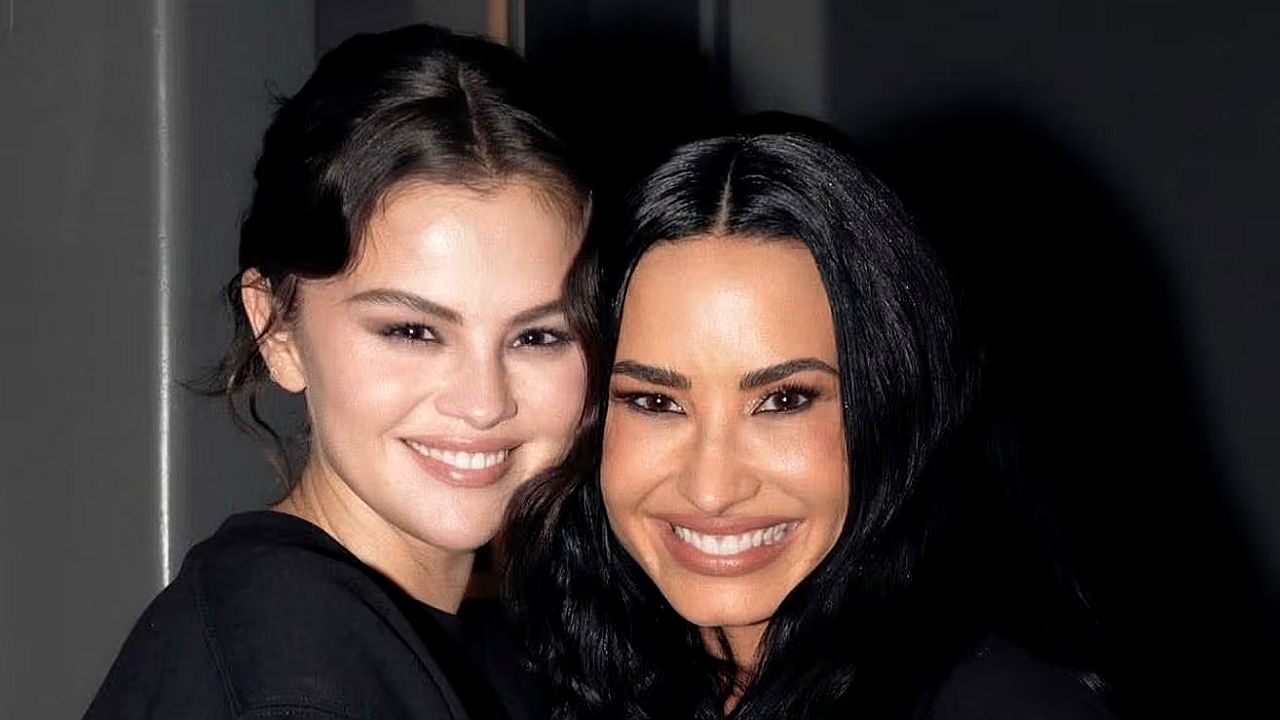 Duas mulheres sorriem juntas em close durante encontro, posando para foto em ambiente interno
