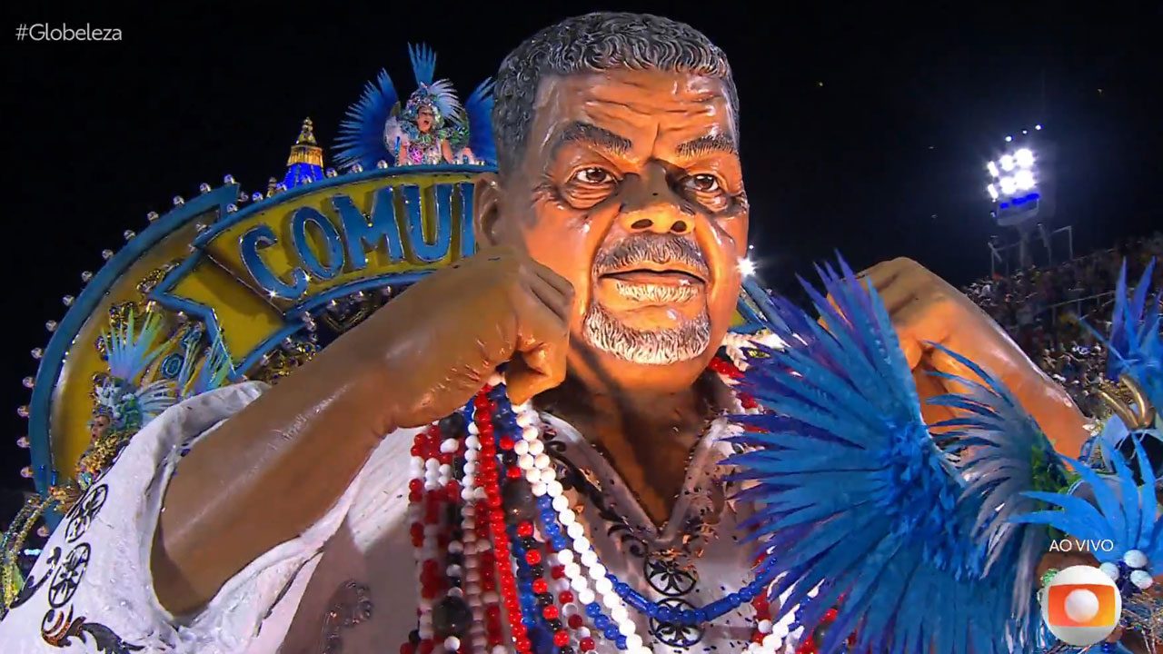 Carro alegórico da Beija-Flor com escultura de Laíla em desfile do enredo Laíla de todos os santos na Sapucaí