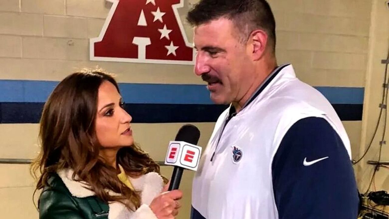 Repórter entrevista homem com microfone da ESPN em ginásio com logo da NFL ao fundo