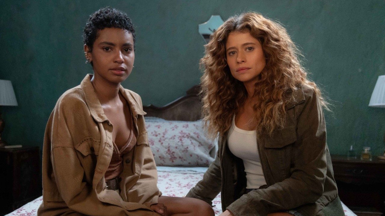 Eduarda interpretada por Gabz e Agrado vivida por Isadora Cruz sentadas em cama com expressão tensa em cena de Coração Acelerado