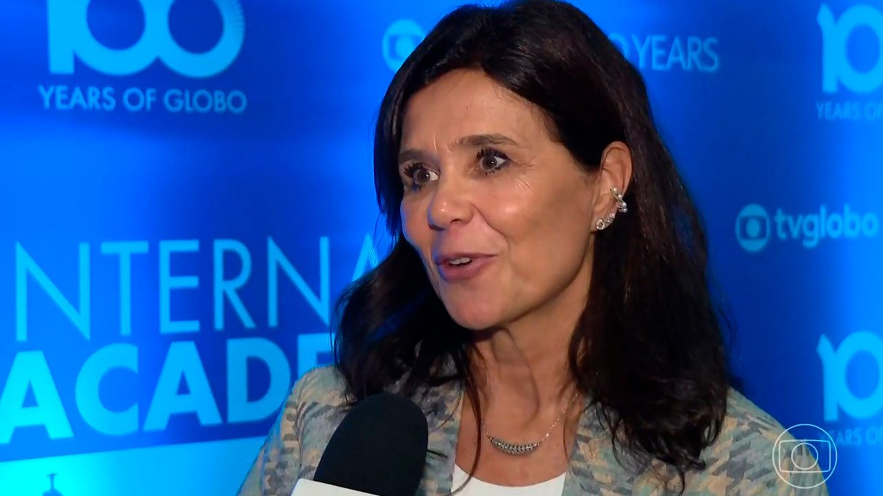 Elisabetta Zenatti durante entrevista ao Jornal Nacional em evento da Globo com painel azul ao fundo exibindo logotipos da emissora