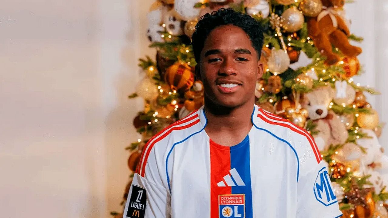 Endrick sorri com camisa do Olympique Lyonnais diante de árvore de Natal iluminada em foto promocional do clube