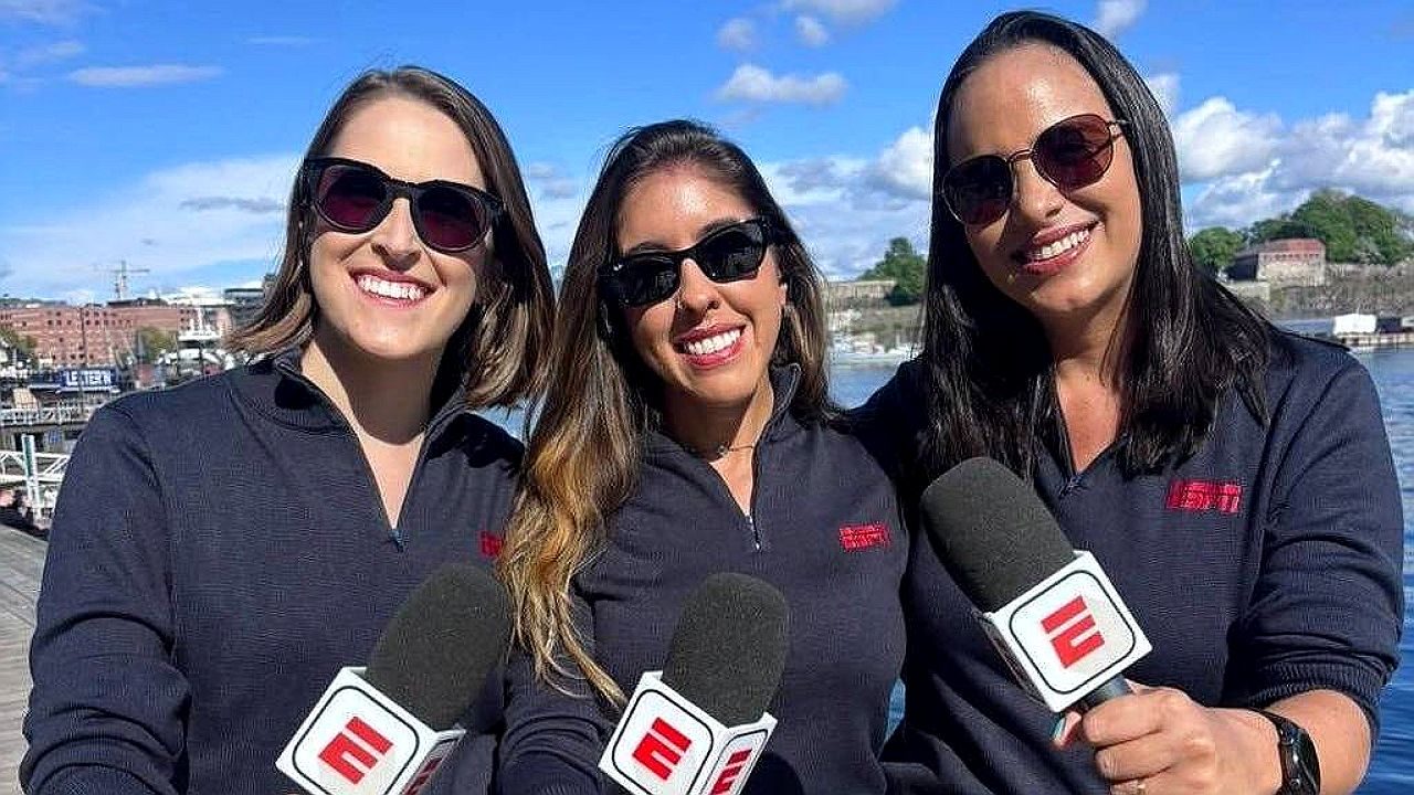 Trio de repórteres da ESPN posa com microfones durante cobertura esportiva ao ar livre
