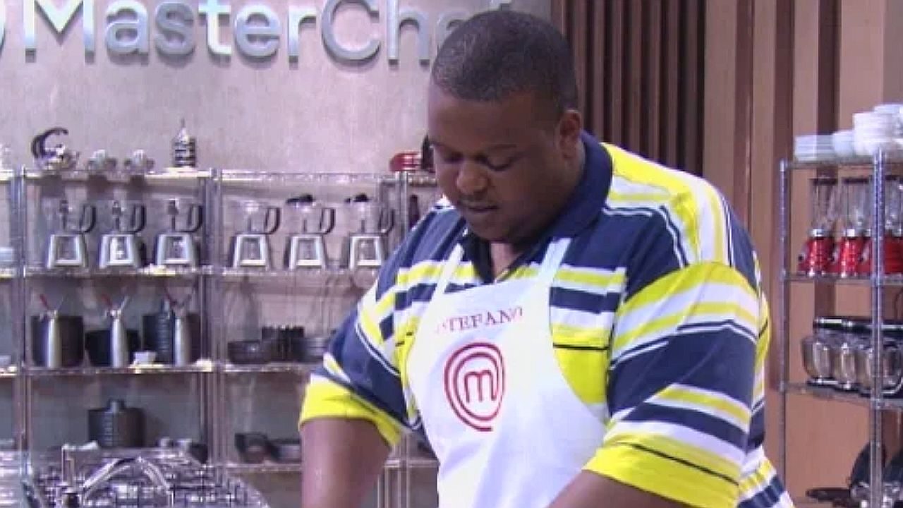 Estefano prepara receita na cozinha do MasterChef Brasil durante desafio culinário