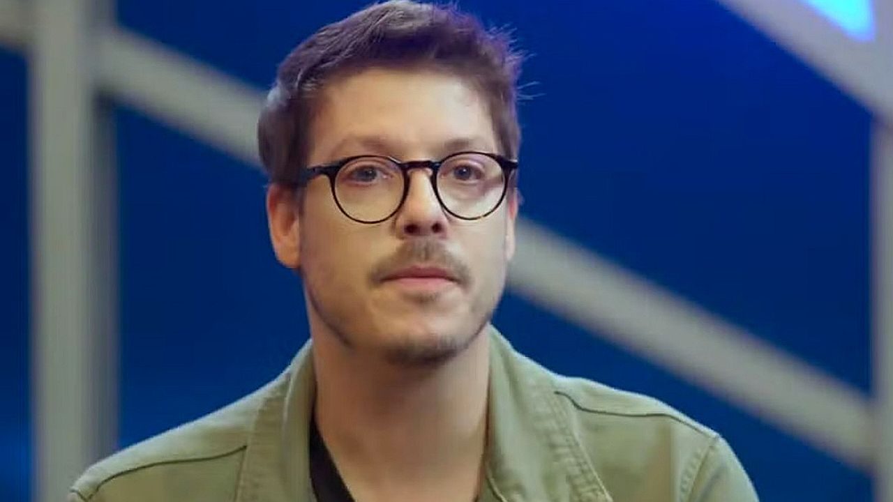 Jovem de óculos com expressão emocionada durante depoimento
