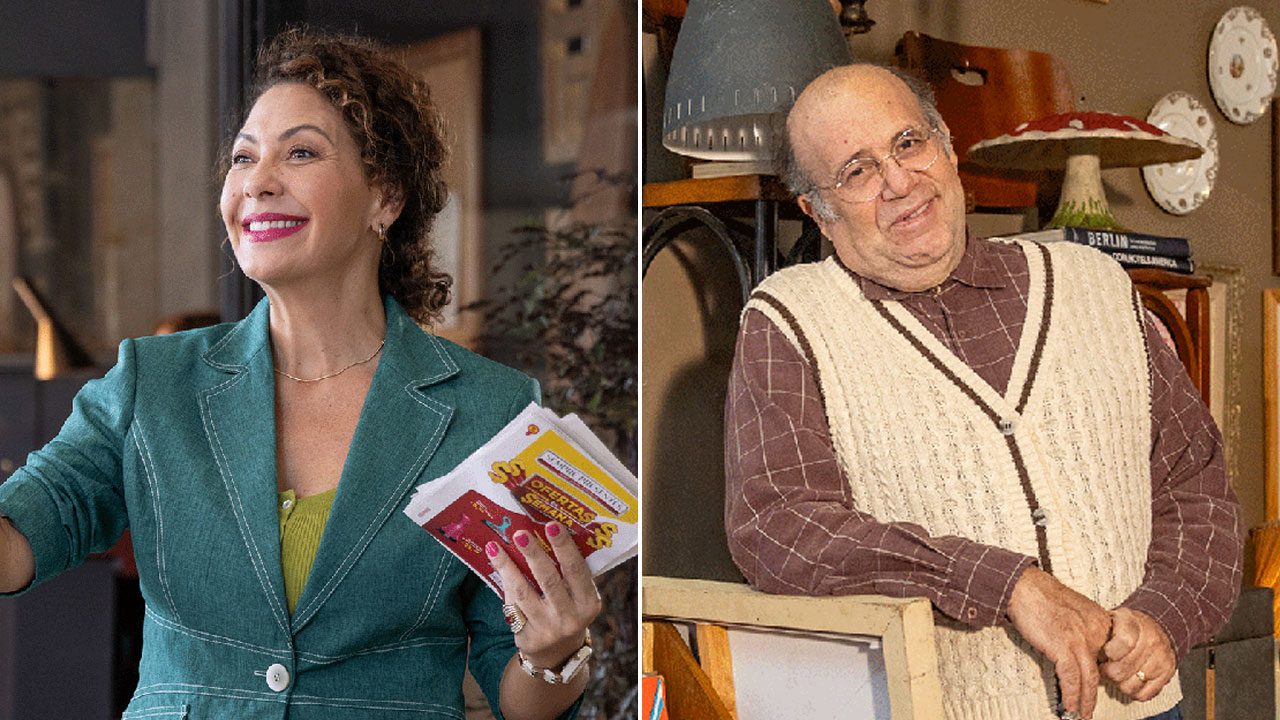 Martina (Fabiula Nascimento) sorrindo com panfletos e Reginaldo (Otávio Muller) encostado em móvel em cena de Volte Sempre no Multishow