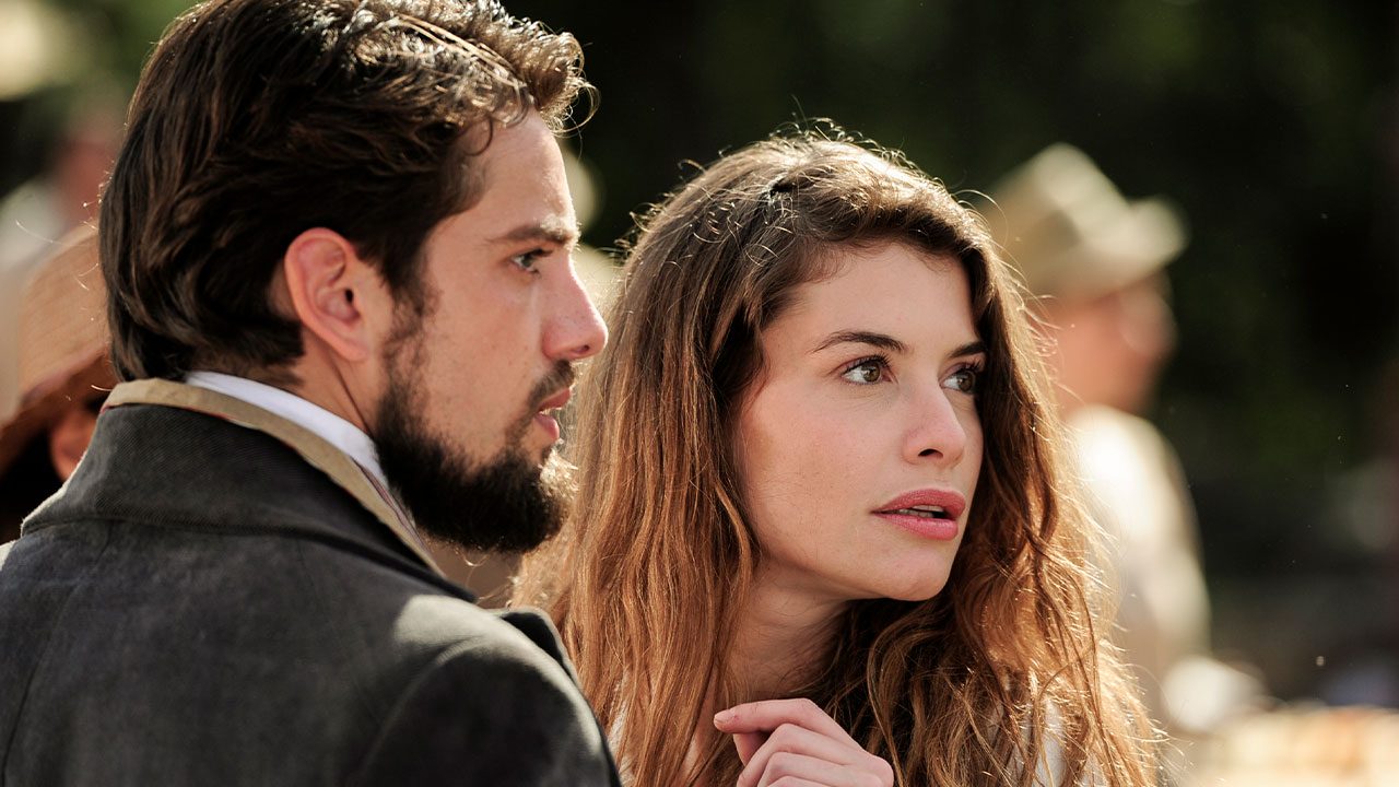 Felipe interpretado por Rafael Cardoso e Lívia vivida por Alinne Moraes observam algo com expressão tensa em cena de Além do Tempo