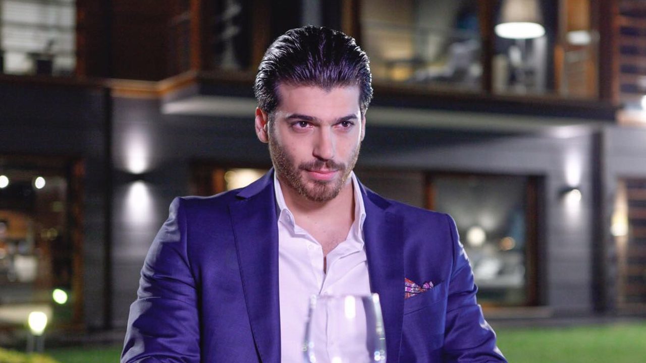 Can Yaman caracterizado como Ferit usando terno azul em cena noturna da novela Dolunay