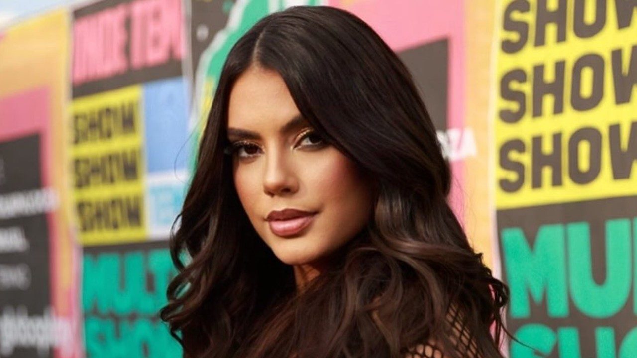 Fernanda Bande com cabelos longos posa diante de painel colorido em evento do Multishow