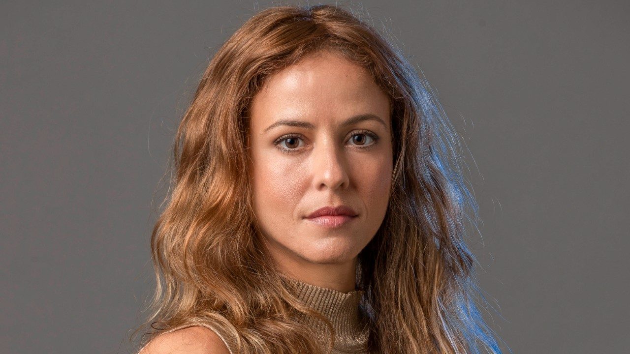 Fernanda de Freitas encara a câmera com expressão séria em retrato com fundo neutro e iluminação suave