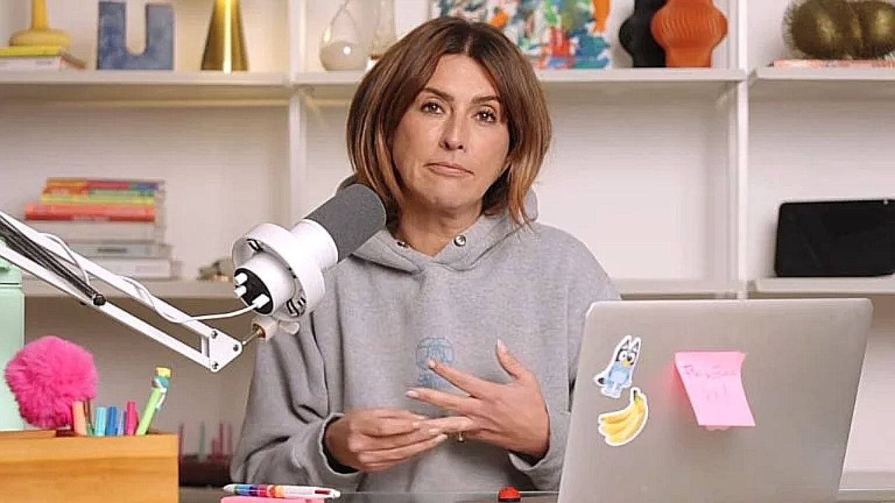 Fernanda Paes Leme grava podcast diante de microfone e notebook em estúdio com prateleiras ao fundo