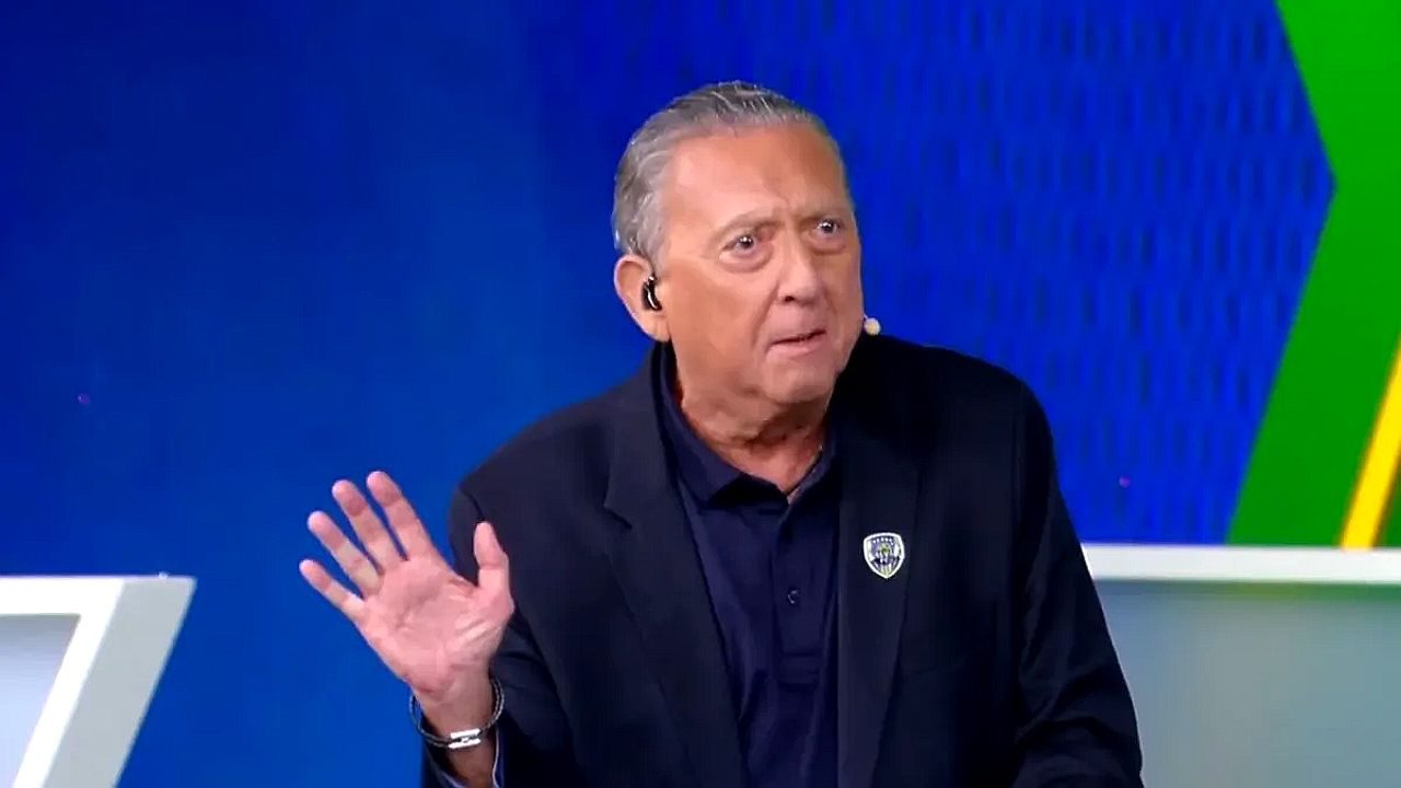 Galvão Bueno gesticula durante participação em programa esportivo com cenário azul ao fundo