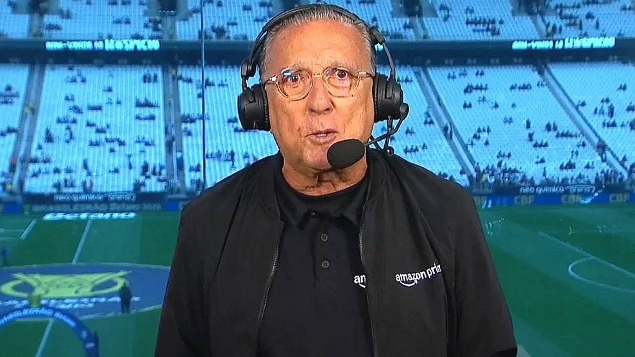 Galvão Bueno usa headset durante transmissão esportiva em estádio com logo do Amazon Prime Video