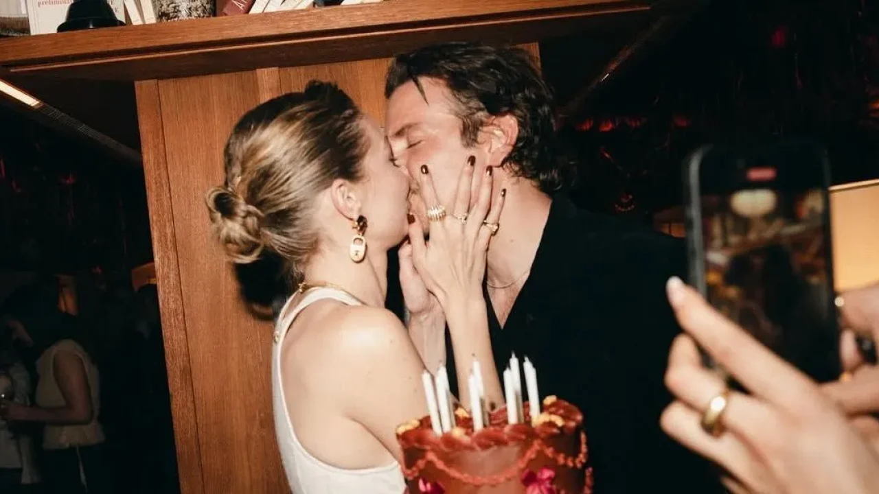 Gigi Hadid e Bradley Cooper se beijando ao lado de bolo com velas durante festa íntima com amigos