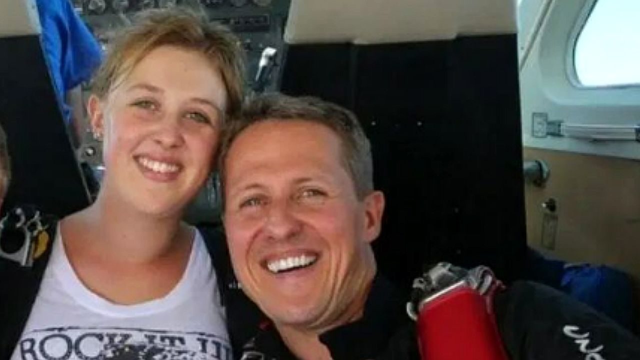 Michael Schumacher posa sorrindo ao lado de jovem em foto dentro de avião após salto de paraquedas