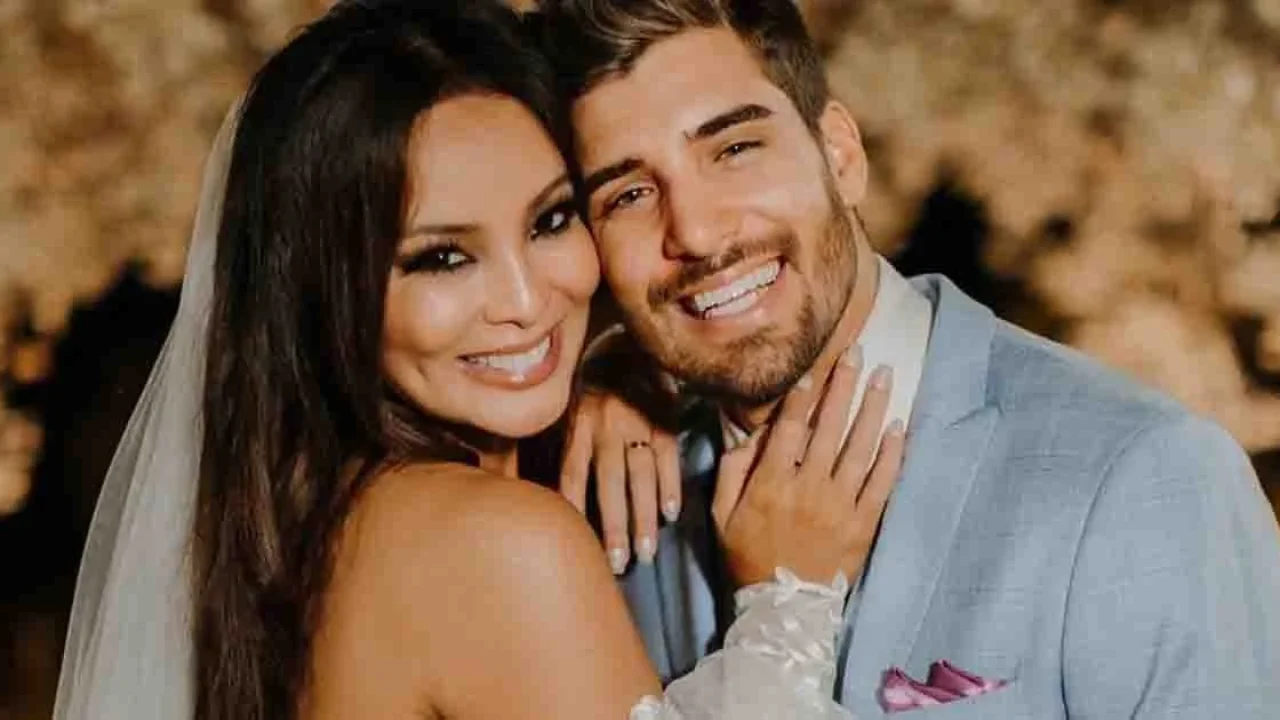 Guilherme Leonel e Carol Nakamura sorrindo abraçados em foto do casamento