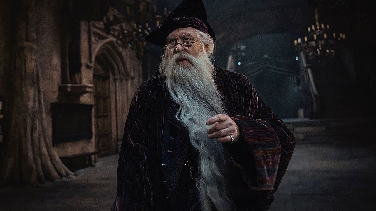 Professor Alvo Dumbledore em cena de Harry Potter dentro de salão de Hogwarts com velas ao fundo