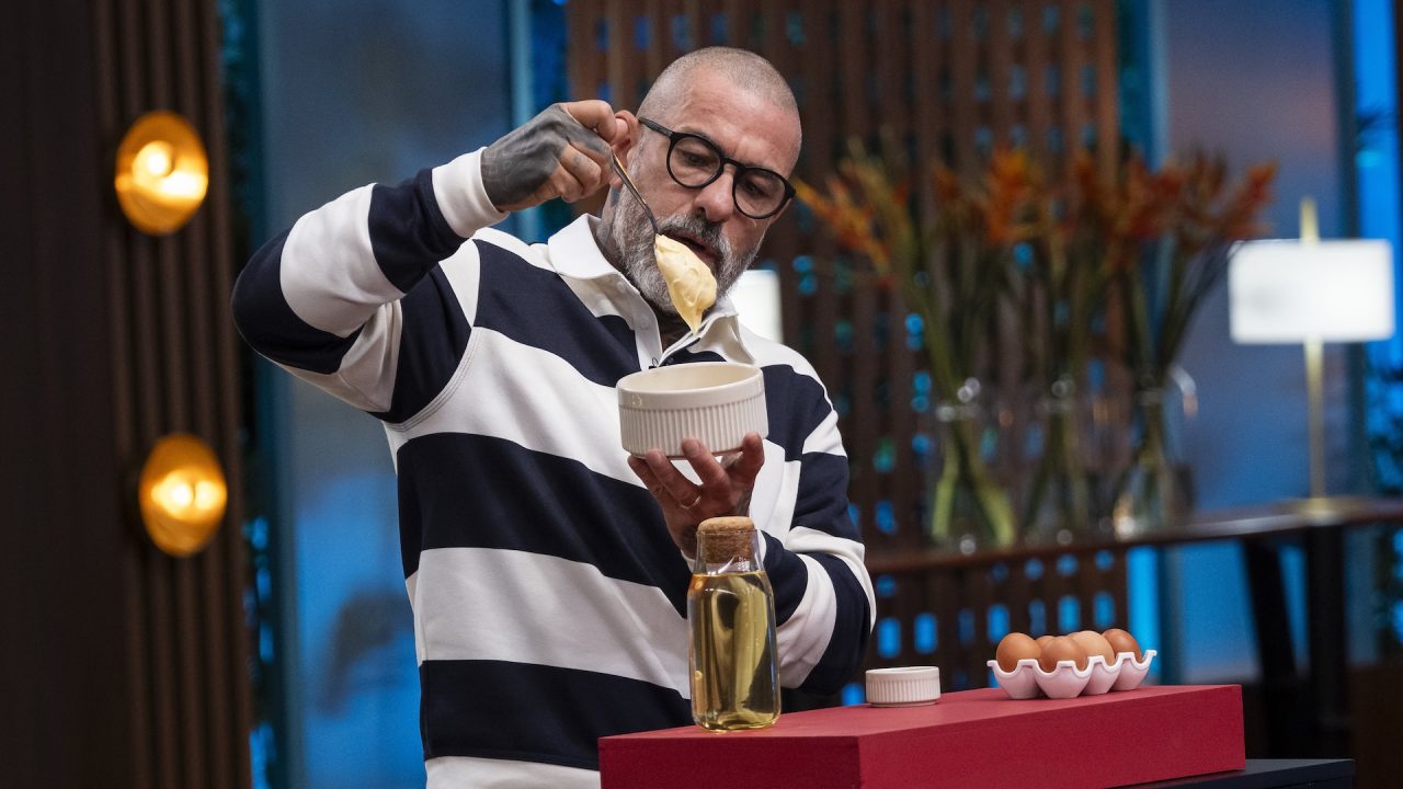 Henrique Fogaça segura tigela com creme durante prova culinária na estreia do MasterChef Brasil 13.