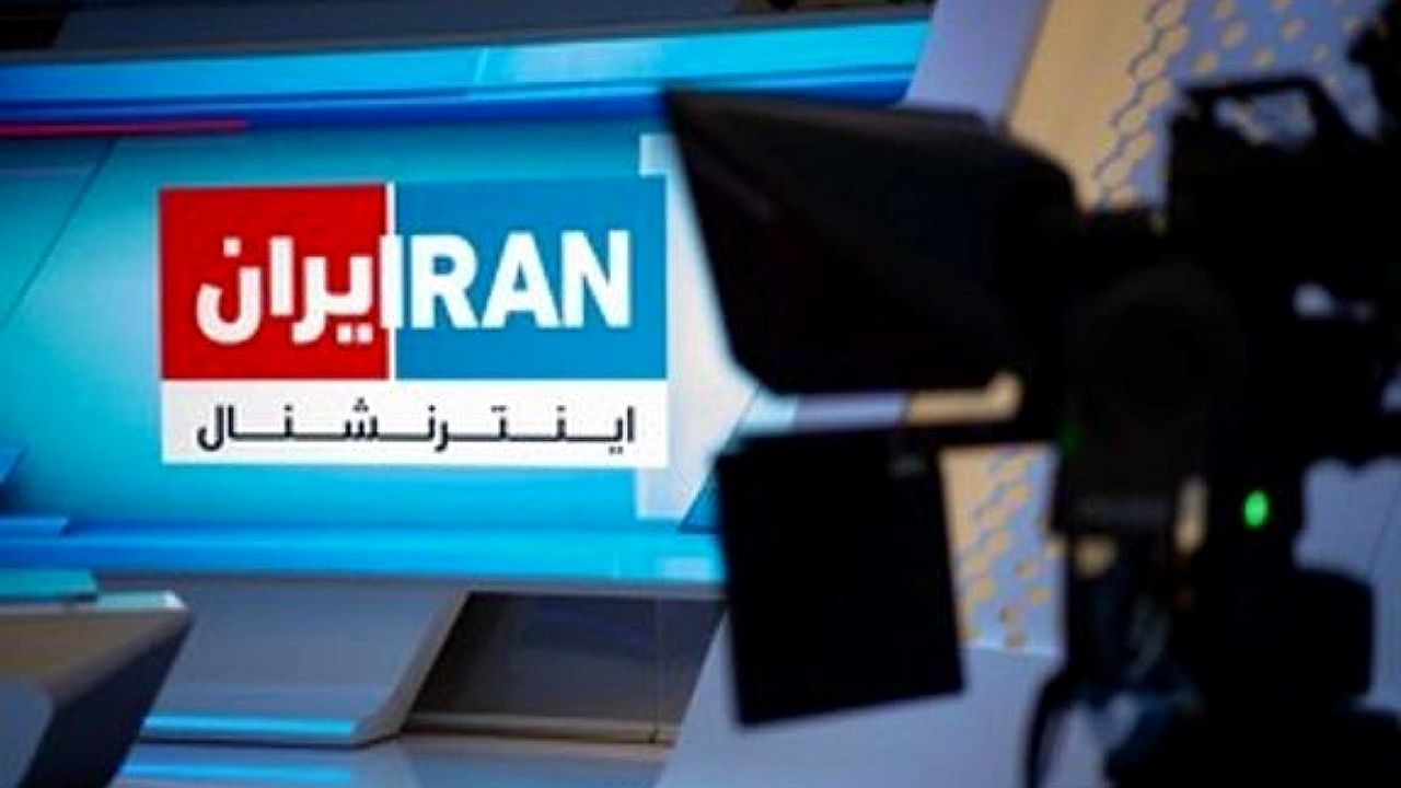 Câmera de TV em estúdio com tela ao fundo exibindo logotipo Iran International em inglês