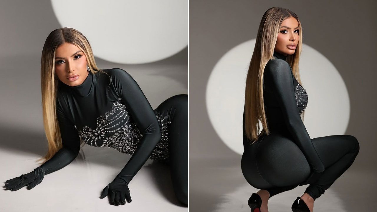 Janaína Prazeres em ensaio fotográfico usando macacão preto com detalhes brilhantes posando em estúdio iluminado