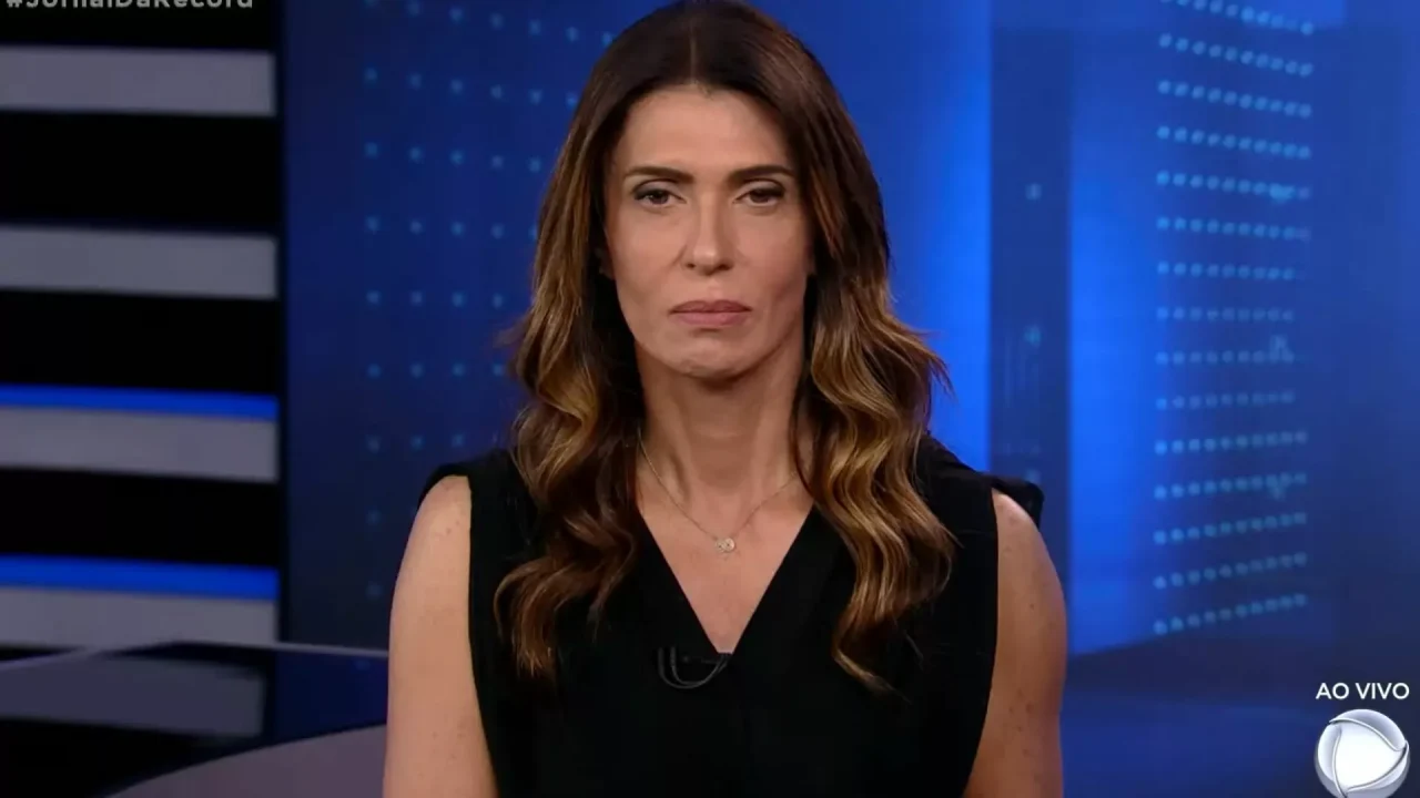 Janine Borba, ex-apresentadora da Record, com uma regata preta em um fundo azul