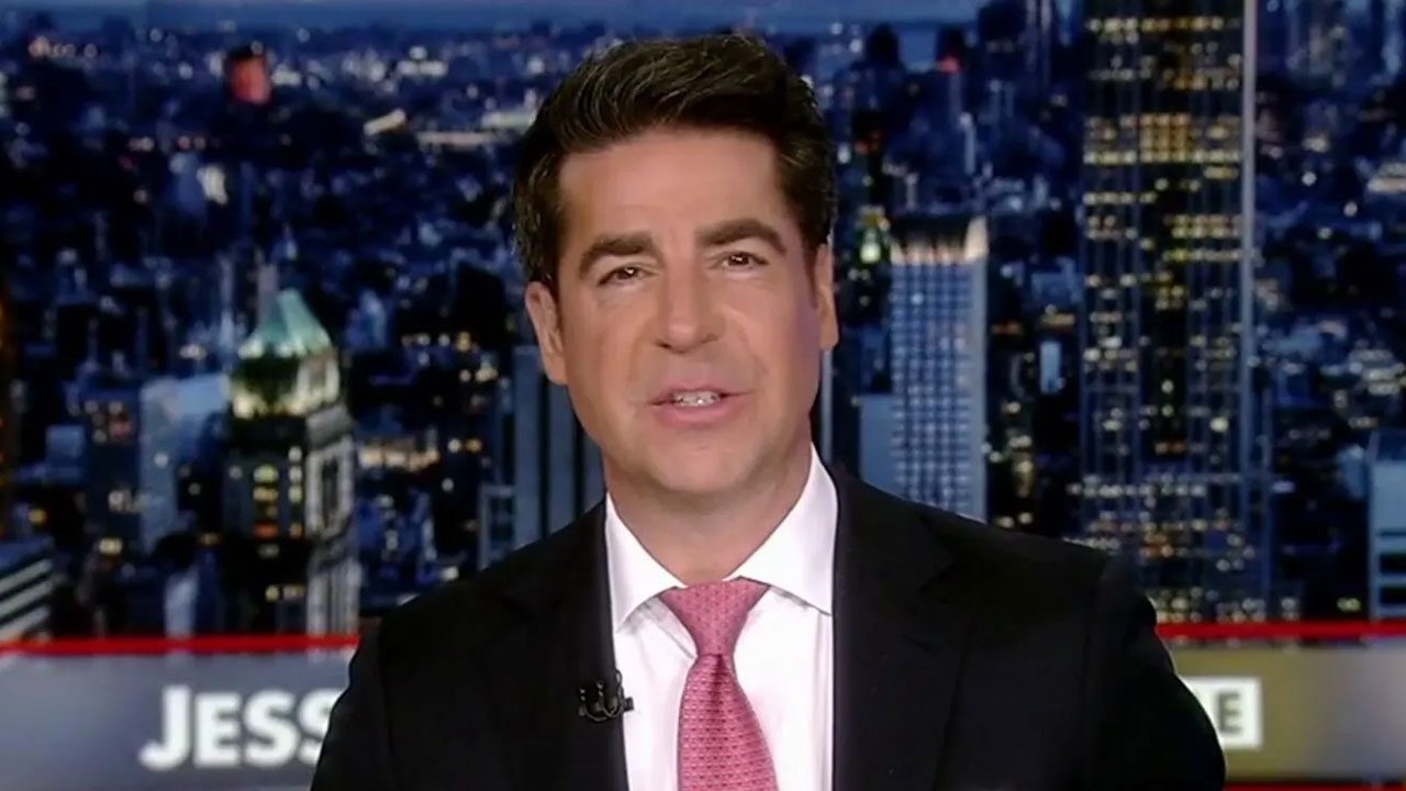 Apresentador Jesse Watters da Fox News veste terno escuro e gravata rosa em estúdio com fundo desfocado de cidade iluminada à noite em New York