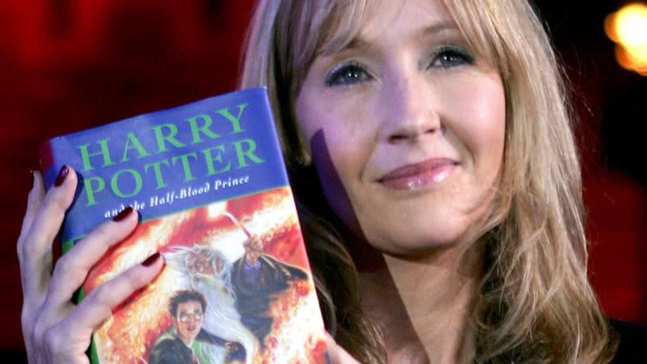 J.K. Rowling segurando um livro da franquia Harry Potter