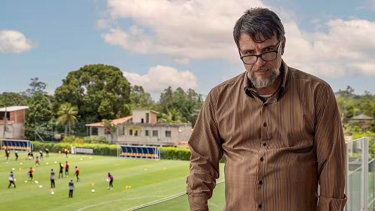 Rodrigo Lombardi observa campo de futebol em cena da série Jogada de Risco