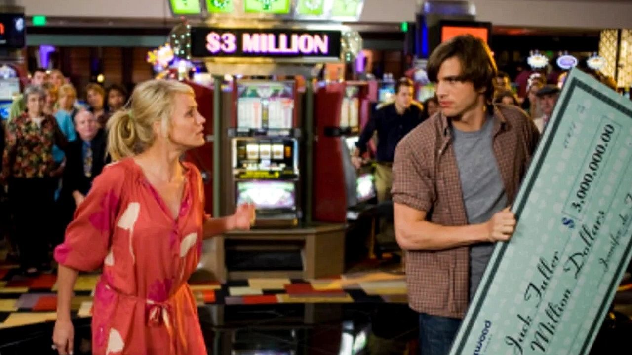 Cameron Diaz e Ashton Kutcher discutem em cassino enquanto carregam cheque milionário em cena de Jogo de Amor em Las Vegas