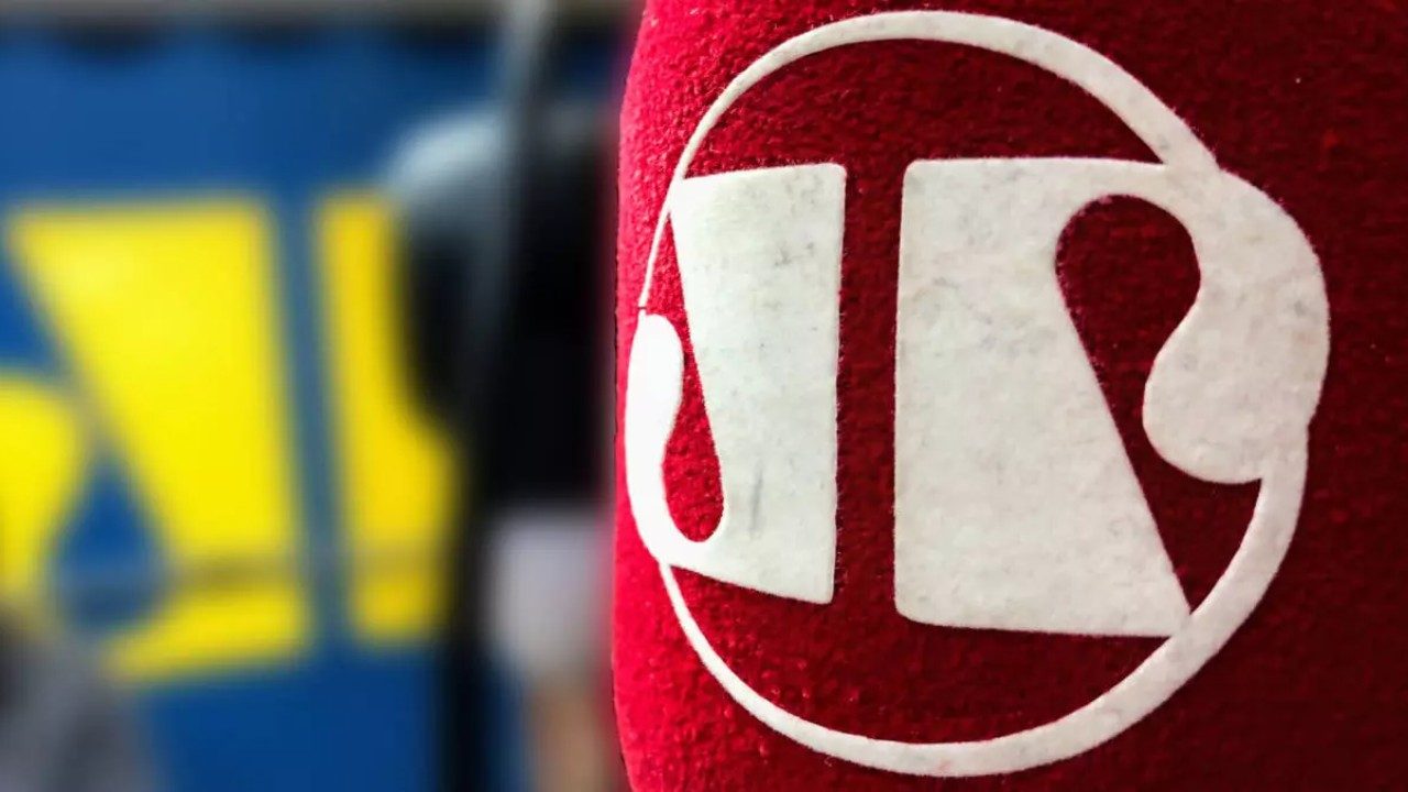 Microfone da Jovem Pan com logotipo da emissora em destaque e fundo desfocado