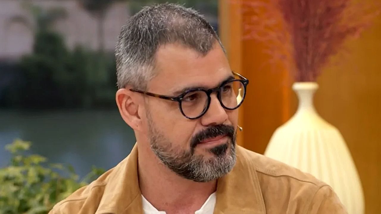 Juliano Cazarré usa óculos durante entrevista em programa matinal de televisão com ponto eletrônico no rosto
