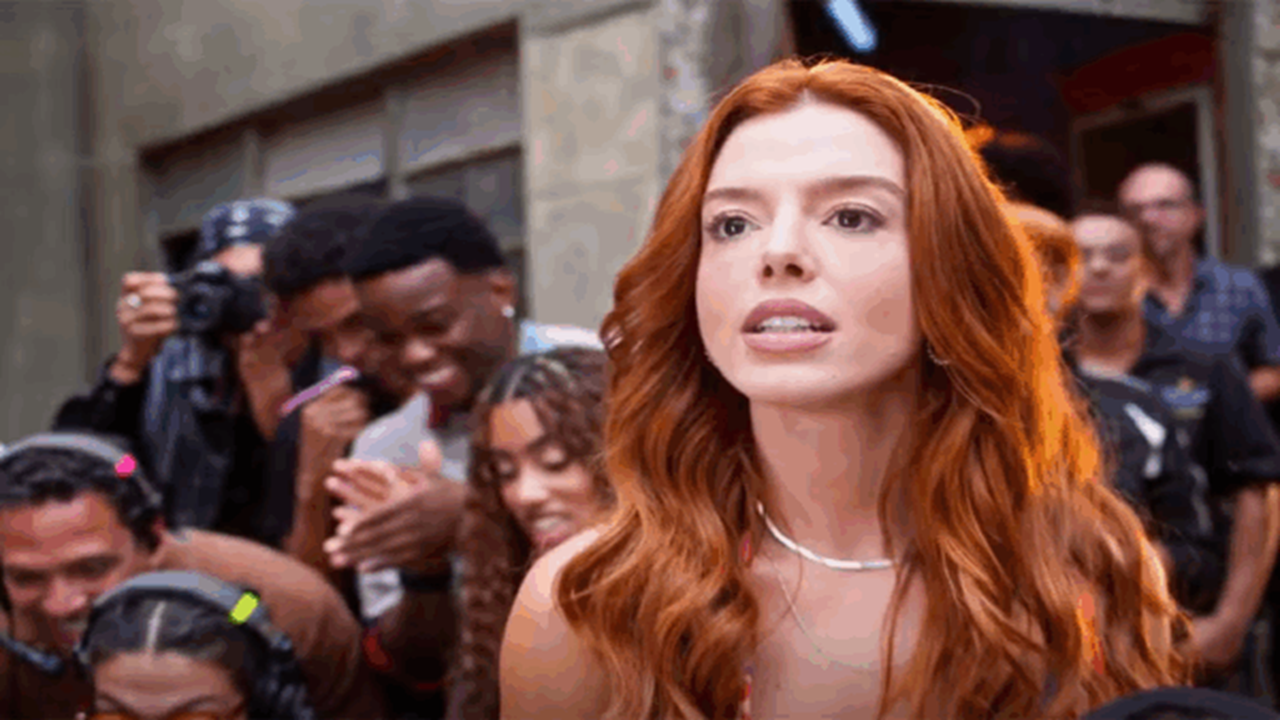 Kami com expressão determinada em meio à multidão em cena de Dona de Mim