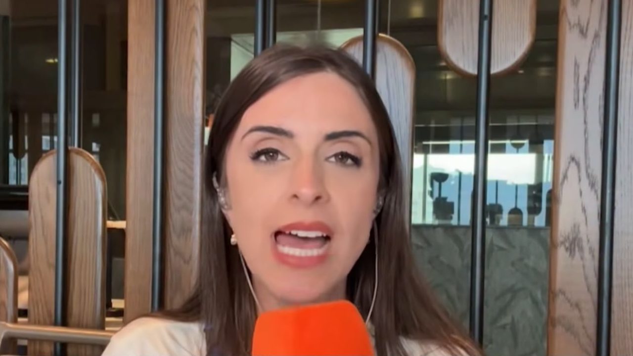 Kelly Matos fala ao microfone durante transmissão ao vivo com fones de ouvido em ambiente interno