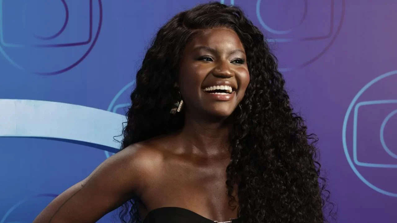 Kenya Sade em um fundo roxo com o logo da Globo