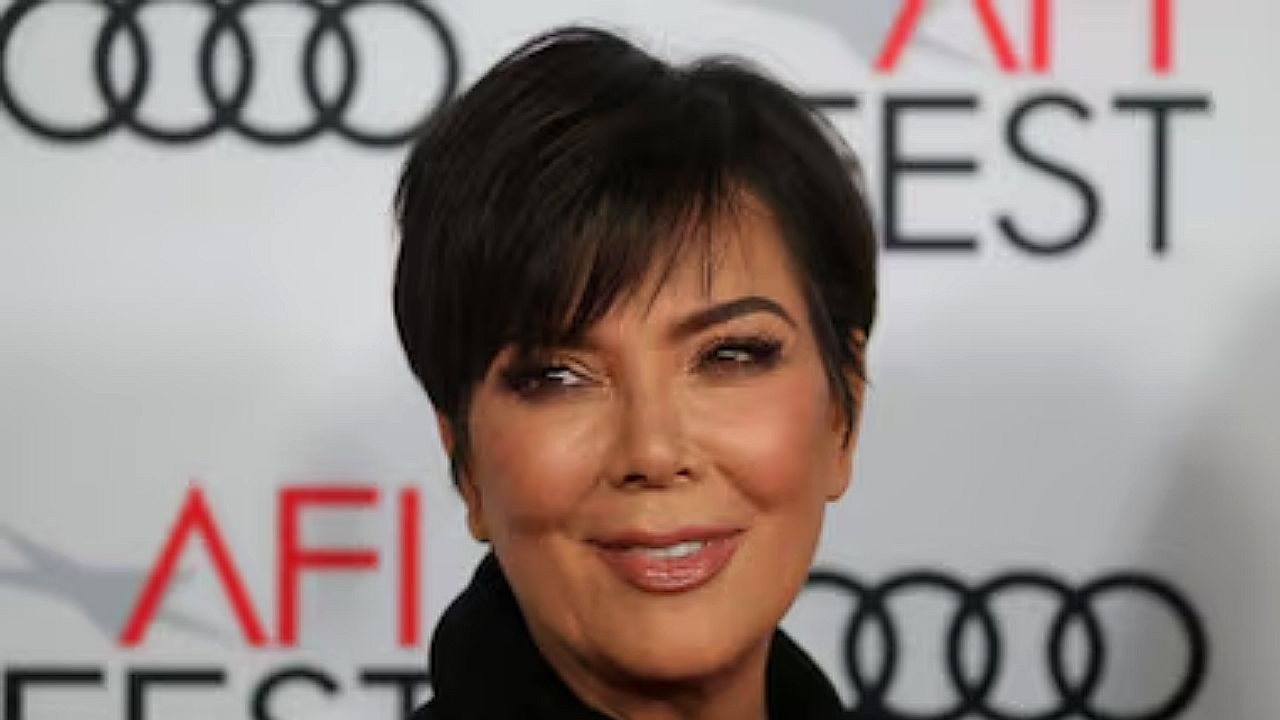 Mulher de cabelo curto posa em evento com logotipos do AFI Fest e da Audi ao fundo