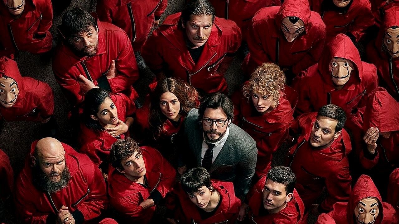 Grupo de assaltantes com macacões vermelhos e máscaras olha para cima em pôster de La Casa de Papel