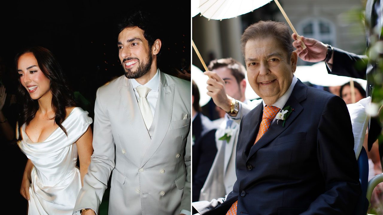 Lara Silva de vestido branco caminha de mãos dadas com Julinho Casares de terno claro ao lado de foto de Fausto Silva sorrindo de terno escuro e gravata laranja em cerimônia