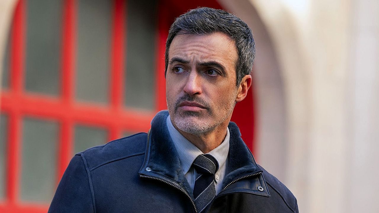 Detetive de terno e casaco observa movimentação em cena da série Law & Order: Organized Crime