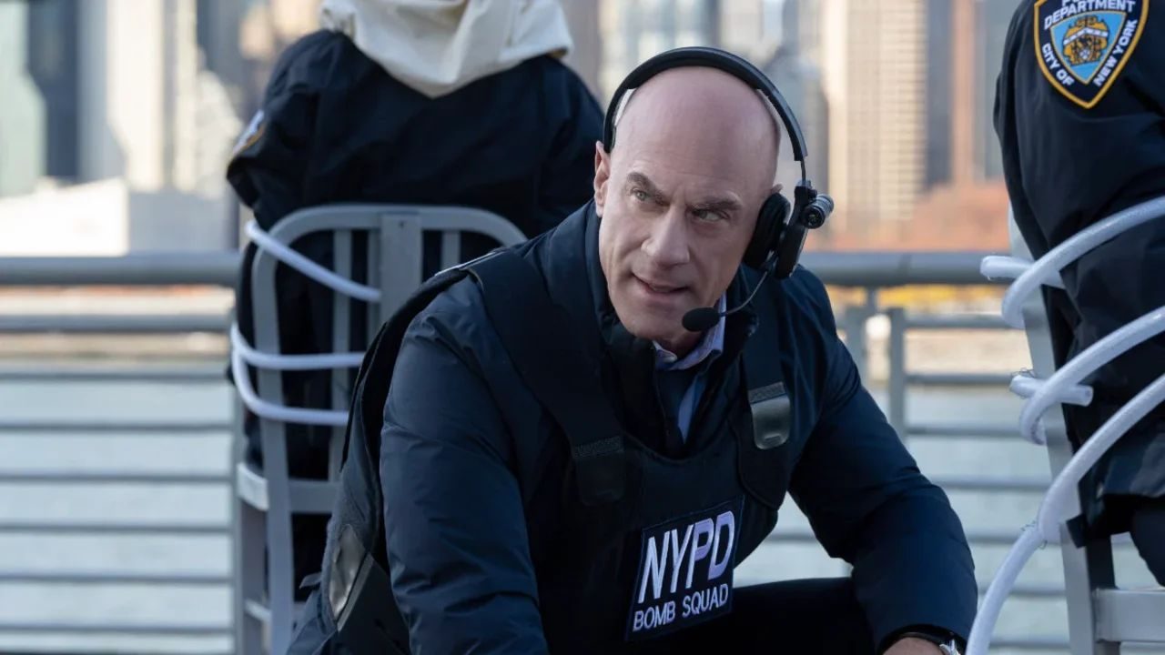 Agente do NYPD com colete da bomb squad e headset durante operação policial em área urbana