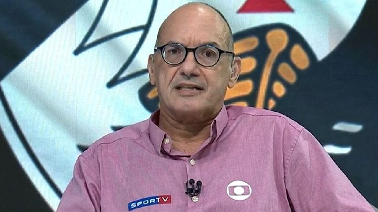Apresentador de óculos comenta futebol em estúdio com logotipo do Corinthians ao fundo durante programa do SporTV
