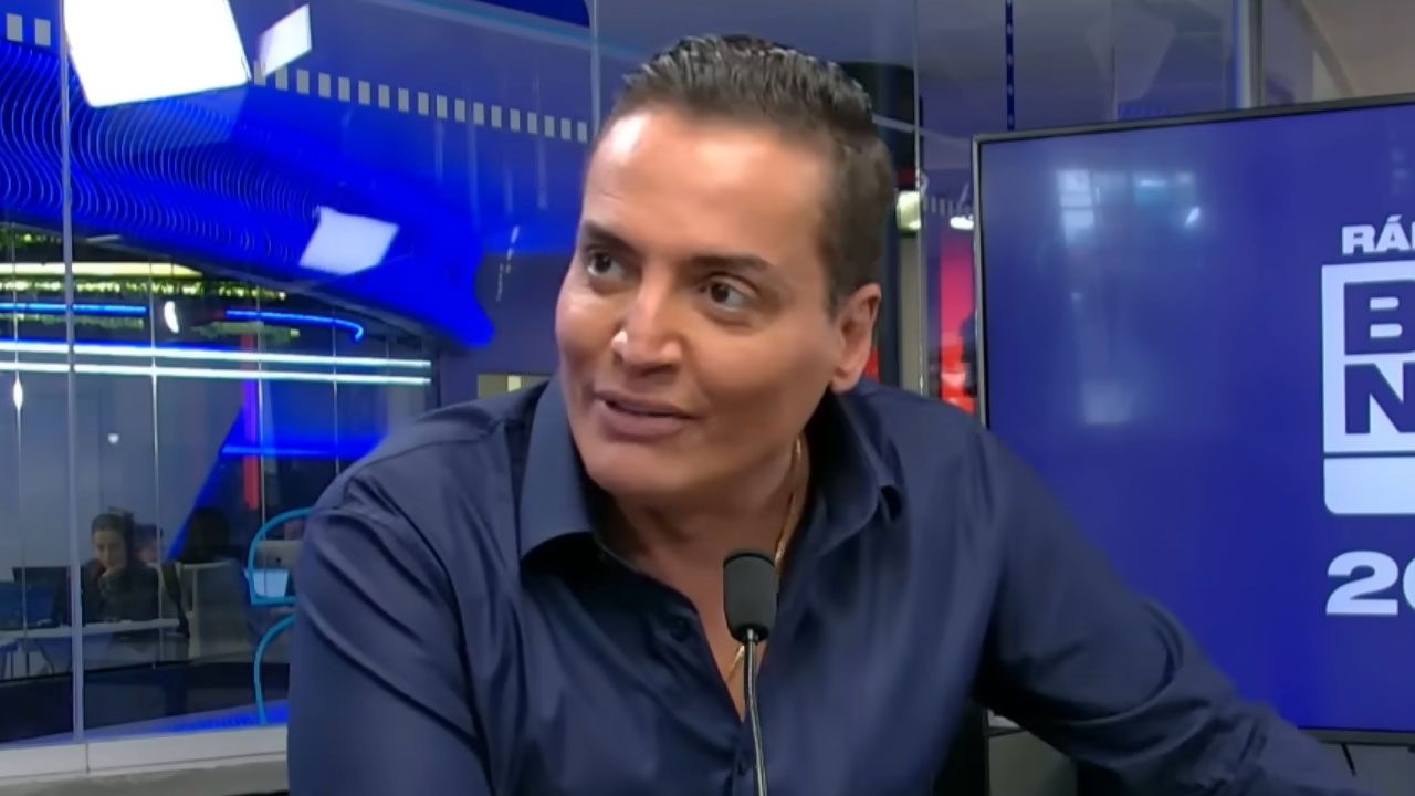 Leo Dias durante participação em programa da rádio BandNews FM, falando ao microfone no estúdio