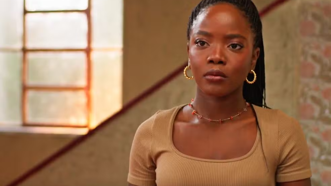 Leo com uma roupa marrom e uma escadaria atrás