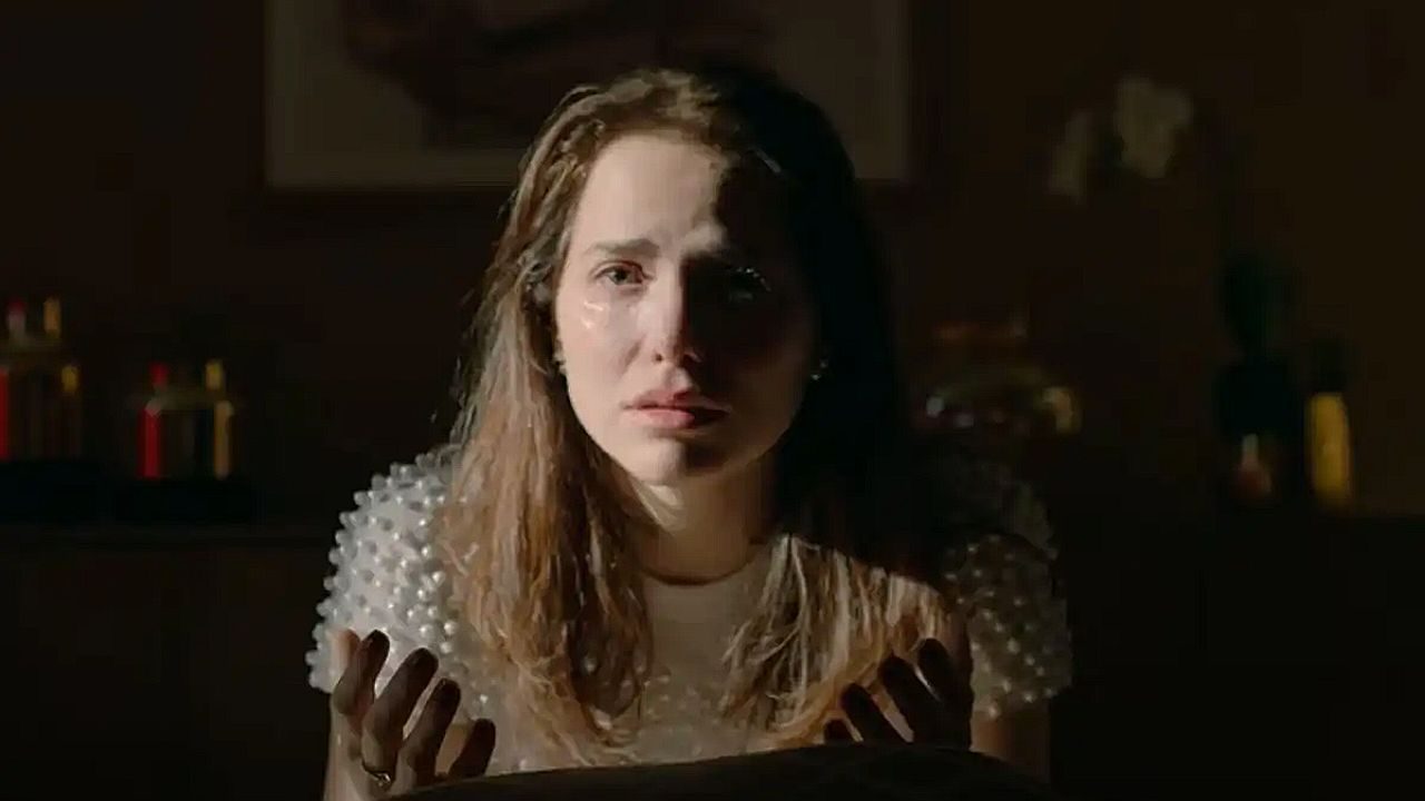 Mulher chora com lágrimas no rosto enquanto encara alguém em cena dramática de novela em ambiente escuro